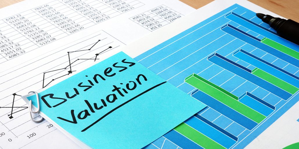 Data of a business valuation presented two pages, one graph and one data with highlighter and sticky note.